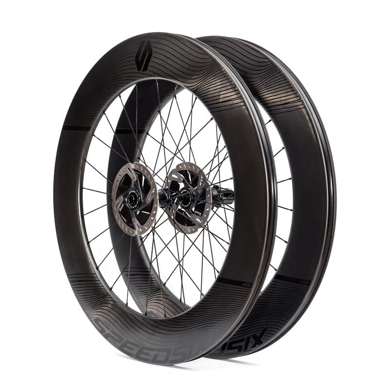 Dos aros de bicicleta de carbono con perfil alto, colocados uno frente al otro, ideales para optimizar la aerodinámica y el rendimiento en ruta. La imagen muestra uno de los tipos de aros de bicicleta más eficientes disponibles en Speedsix México.